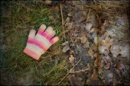 Lost pink glove on grass and frosted oak leaves, Richmond Park, Surrey