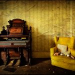 Harmonium and yellow armchair, derelict Manor House 'B', Norfolk, UK