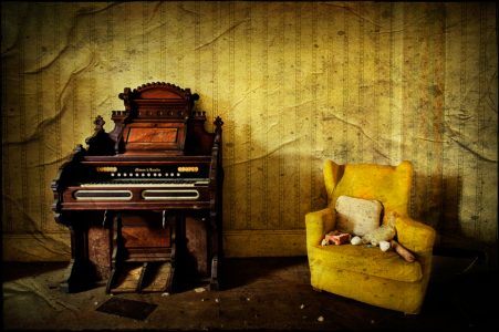Harmonium and yellow armchair, derelict Manor House 'B', Norfolk, UK
