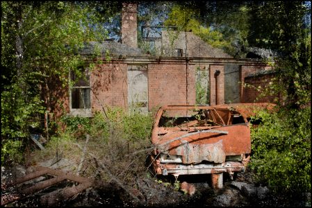Rusted car outside mortuary, derelict Hellingly Asylu, West Sussex, UK